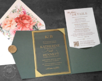 Clear acrylic invitation with gold border, green pocket folder, and floral envelope liners