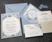 Dusty Blue Floral Invitation with watercolor flowers in shades of blue, pocket backer, and monogram crest envelope liners