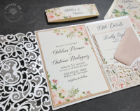 Pink Floral Lace Invitation with pink and cream watercolor flowers mounted with a pink backing layer inside a ivory laser cut lace pocket folder
