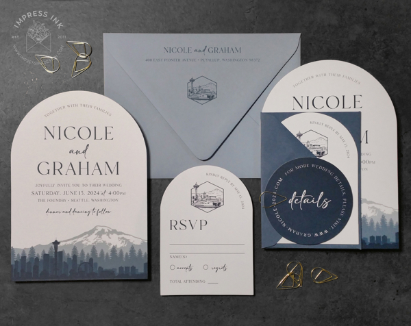 Seattle Skyline Arch Invitation with city silhouette in shades of navy blue, ferry boat reply cards, and dusty blue envelopes