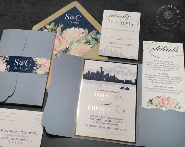 Seattle Skyline Pocket Invitation with city silhouette in shades of navy blue, blush pink floral accents, and gold foil