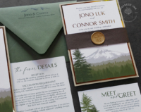 Green Cascade Mountains Invitation with landscape silhouette of Mount Rainier in shades of green, woodgrain bands with gold wax seals, seedling green envelopes