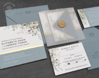 Dusty Blue Greenery Invitation with gold foil accents, wax seals, and translucent vellum wraps.