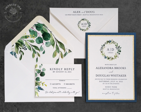 Greenery Wreath Monogram Invitation with gold glitter and navy backing layers, matching greenery envelopes liners