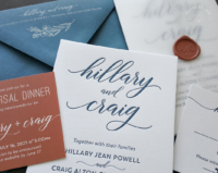 Modern Script Letterpress Invitation with bold names in navy letterpress imprint, slate envelopes with floral line art print, pops of rust orange