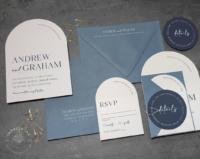 Modern Blue Arch Invitation with white arch cards, slate blue envelopes, navy circle details cards, and gold teardrop paperclips